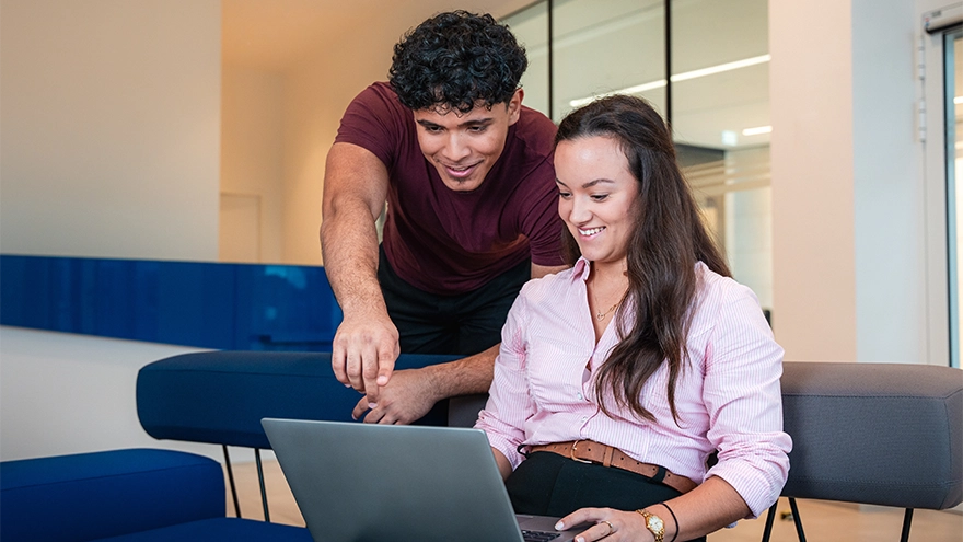 Zwei Auszubildende sitzen vor einem Laptop. 