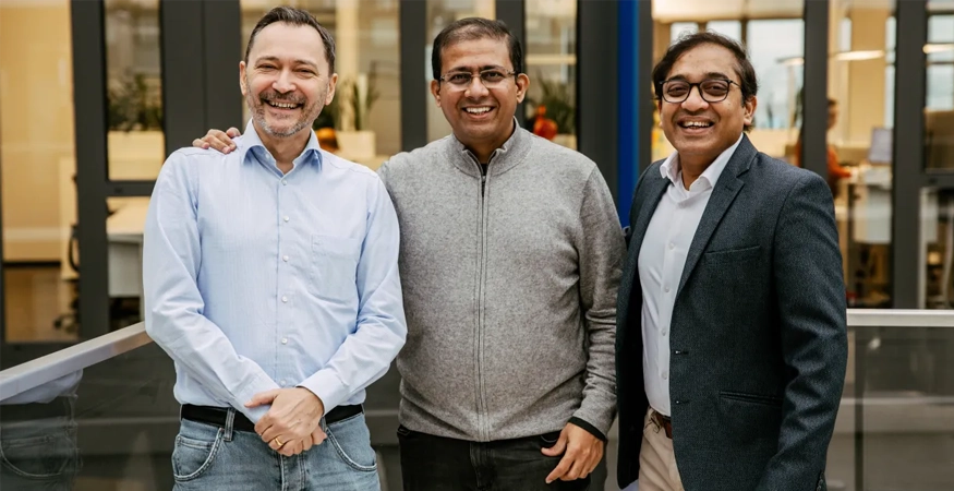 Edward Aston und zwei Kollegen posen für die Kamera und lächeln. 