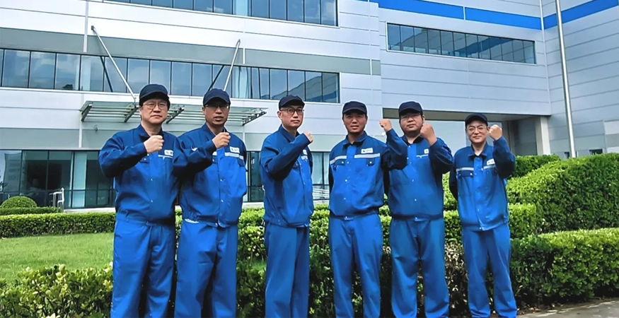 Personen stehen vor einem Gebäude mit Siegerpose.